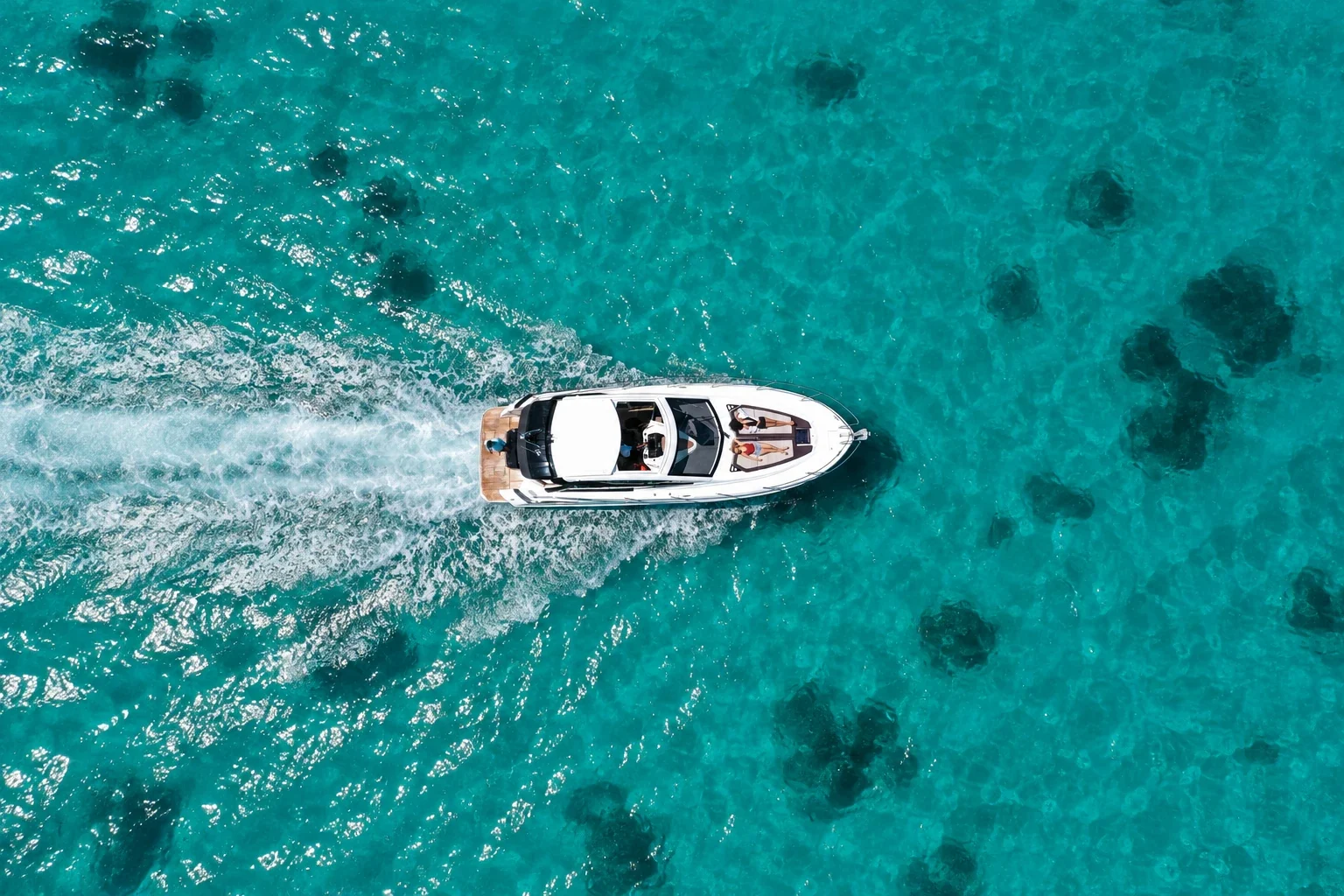 A drone view of Maga-Kani surrounded by clear turquoise lagoon