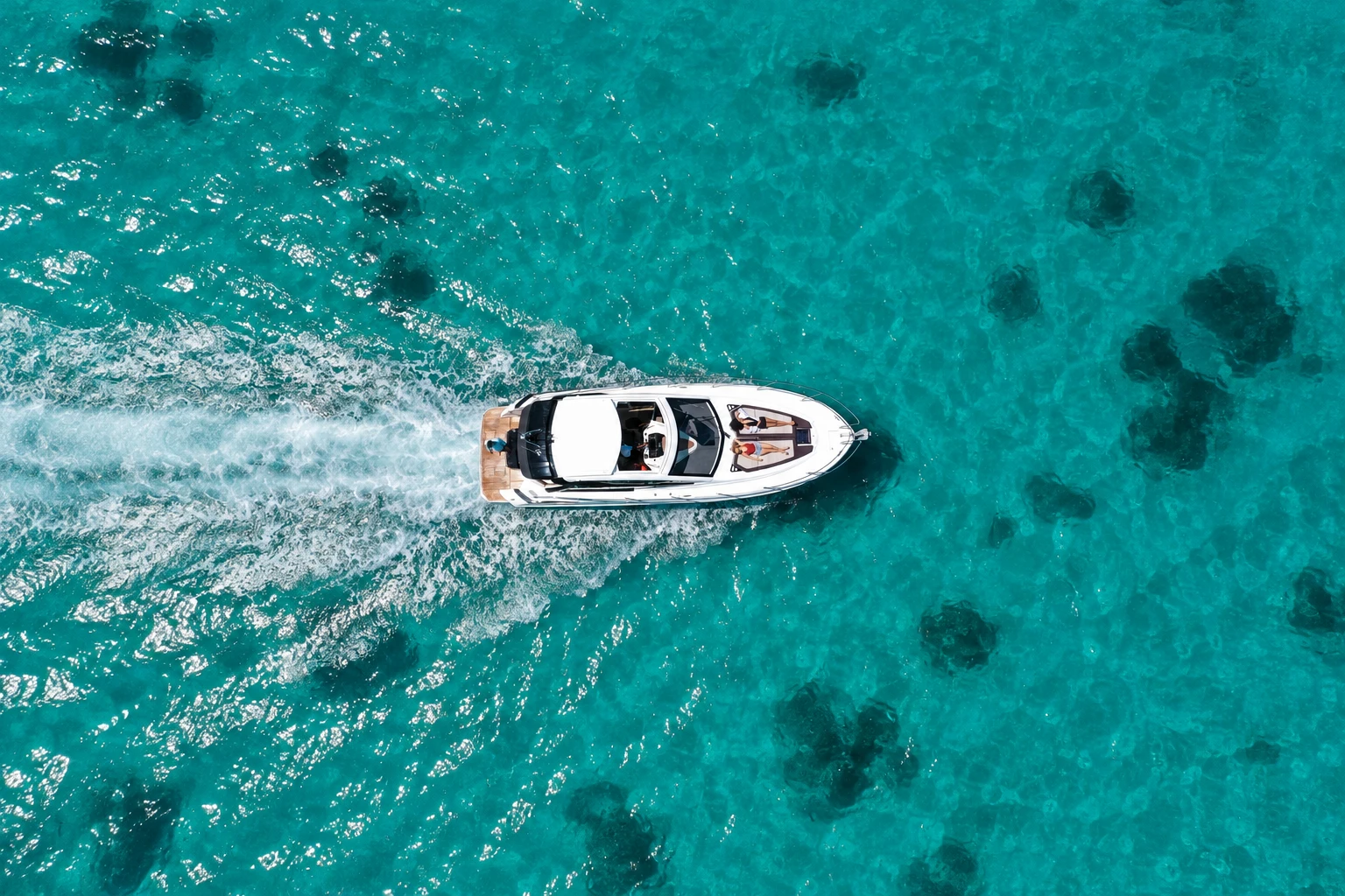 A drone view of Maga-Kani surrounded by clear turquoise lagoon